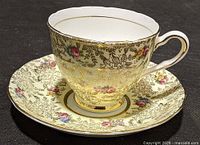 Cup on saucer showing exterior pattern and gold detail