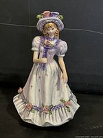 Front view of lavender porcelain Victorian maiden figurine showing dress details and floral accents