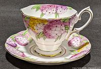 Teacup on saucer showing floral pattern and gold trim