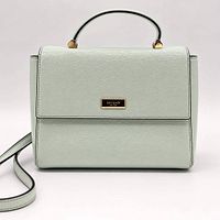 Front view of mint Kate Spade saffiano leather handbag with top handle, flap, crossbody strap attached