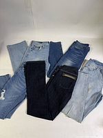 Five pairs of jeans laid out showing assorted washes