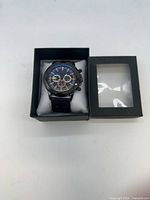 Watch in open display box on cushion showing face and band