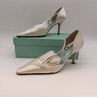 Pair of satin pumps displayed on turquoise Filippa Scott box, showing style and condition