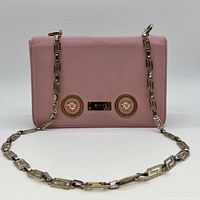 Front view showing pink leather, Medusa head hardware, chain strap