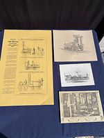 Four of the five unframed prints laid out including yellow 1829 competition poster, locomotive side view, industrial yard print and factory engraving