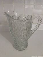 Front view of clear pressed glass pitcher