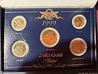 Full set inside case showing five encapsulated gold-plated coins