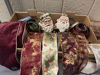 Overall lot showing two Santa stocking hangers and multiple ribbon rolls in tray