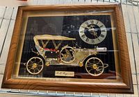 Framed clock front view showing car and dial