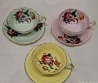 Three pastel Paragon teacup and saucer sets arranged upright