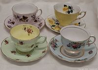 Front view of four floral teacup and saucer sets