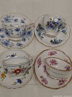 Four teacup and saucer sets showing patterns and colours