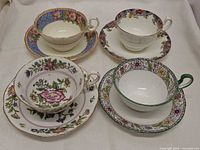 Top view of four Aynsley floral border teacup and saucer sets