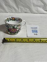 Side view of floral bone china cup with measuring tape