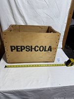 Front view showing PEPSI-COLA graphic and overall crate condition with tape for scale