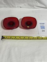 Pair of red glass candle holders top view with ruler showing approx 4 in width