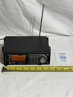 Front view of Uniden BCT15X scanner with antenna and measuring tape