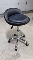 Full view of stool showing seat, chrome base, wheels