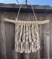 Front view of macrame hanging showing full design on driftwood