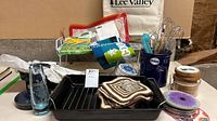 Group shot of all items on table including coaster sets, roasting pan, utensil crock, glass vase, wooden coasters