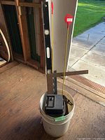 Bucket containing level, framing square, heater and clamps