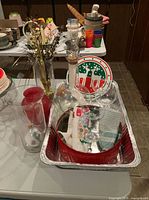 Glassware, vases, plates, tin, towels arranged in aluminum pan