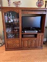 Front view showing glass display door, TV area, drawers and cabinets