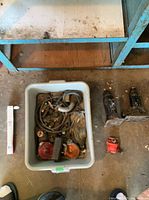 Tote beside two bottle jacks, red pump housing and boxed bulb
