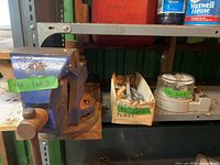 Side view of blue bench vise mounted on shelf