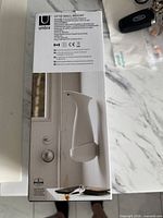 Front of sealed Umbra Otto Wall Mount dispenser box showing product image and specifications