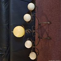 Front view of black metal five-arm candelabra with five round candles displayed