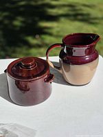 Pitcher and covered sugar pot side by side showing overall design and two-tone glaze