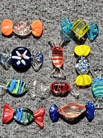 Front view of all ten multicolor glass candy beads on grey background