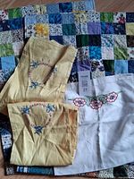 Group shot of quilt, pillowcases and white embroidered linen