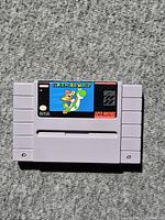 Front view of Super Mario World SNES cartridge showing label and overall cosmetic state