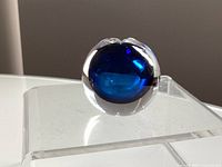 Front angle of spherical clear glass paperweight showing cobalt blue core