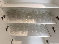 Cabinet shelves filled with assorted Atlantis stemware