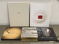 Five hardcover catalogues laid out showing covers and brands