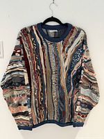 Front view of Coogi multicolour knit sweater hanging on hanger