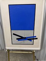 Framed abstract print in silver frame on stand