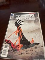 Front cover of Teen Titans #7 comic in protective bag and board