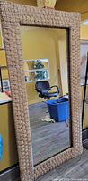 Full view of rectangular mirror leaning against wall