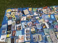 Overhead view of full lot spread on blue tarp showing children’s books, science textbooks, pet guides and workbooks