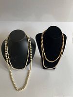 Two necklace busts displaying all four pearl strands
