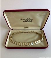 Necklace displayed in open branded presentation box