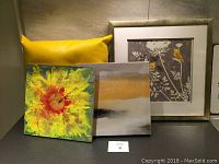 Photo showing all three items: encaustic wax flower painting on board, abstract signed canvas print, and yellow pleather cushion