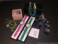 Watches in boxes with crocodile pattern bands plus necklaces including turquoise beads, black disc necklace, green beads and dark blue beads.