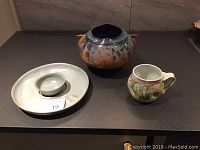 Four pieces of hand thrown pottery displayed together: a large bowl, a serving platter with a small bowl, and a small pitcher.
