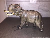 Front side view of large Beswick elephant figurine showing raised trunk and tusks.