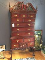 Front view of mahogany tall boy chest, showing full height, drawers and crest.